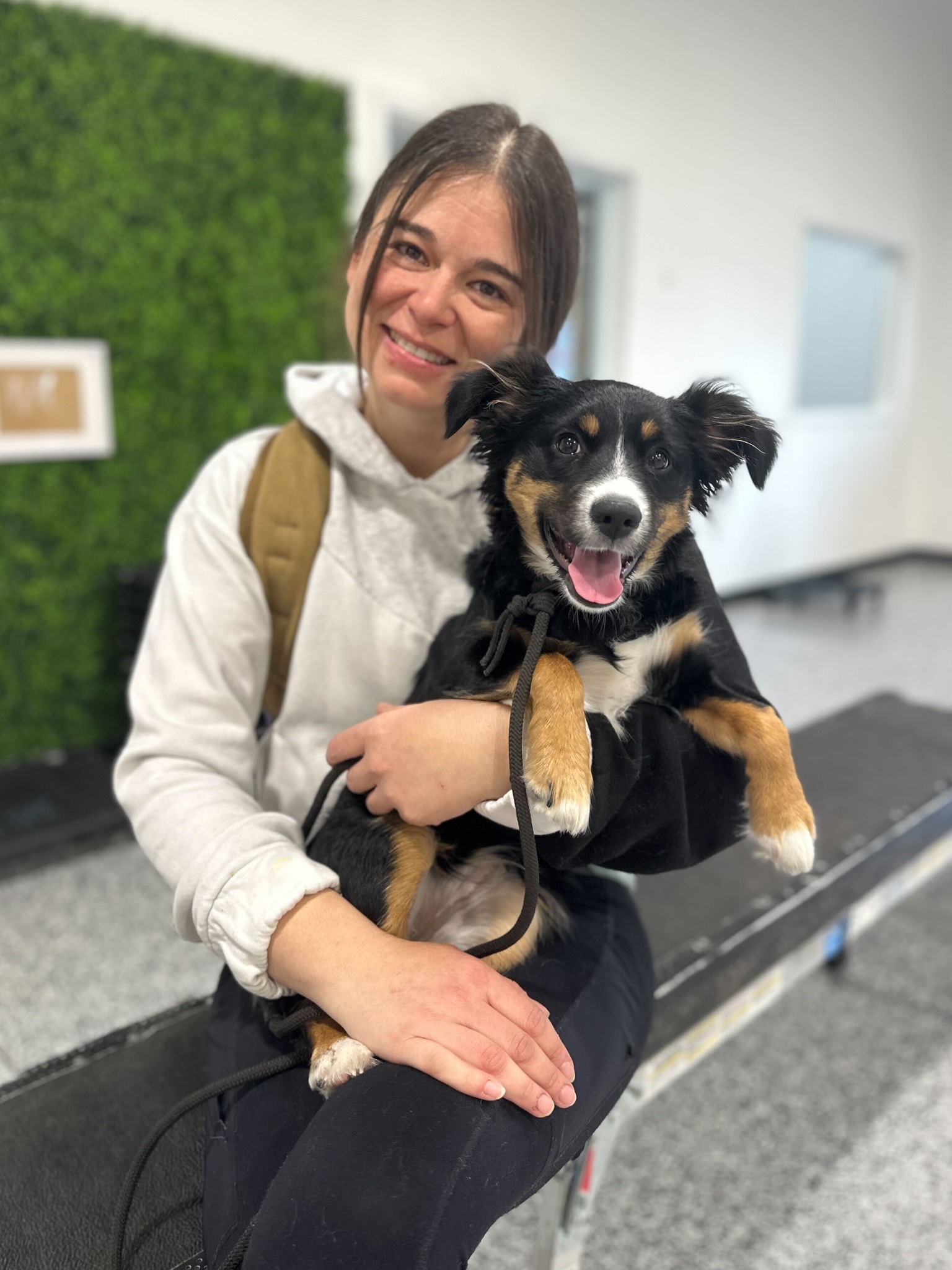 trainer sitting on bench holding smiling dog